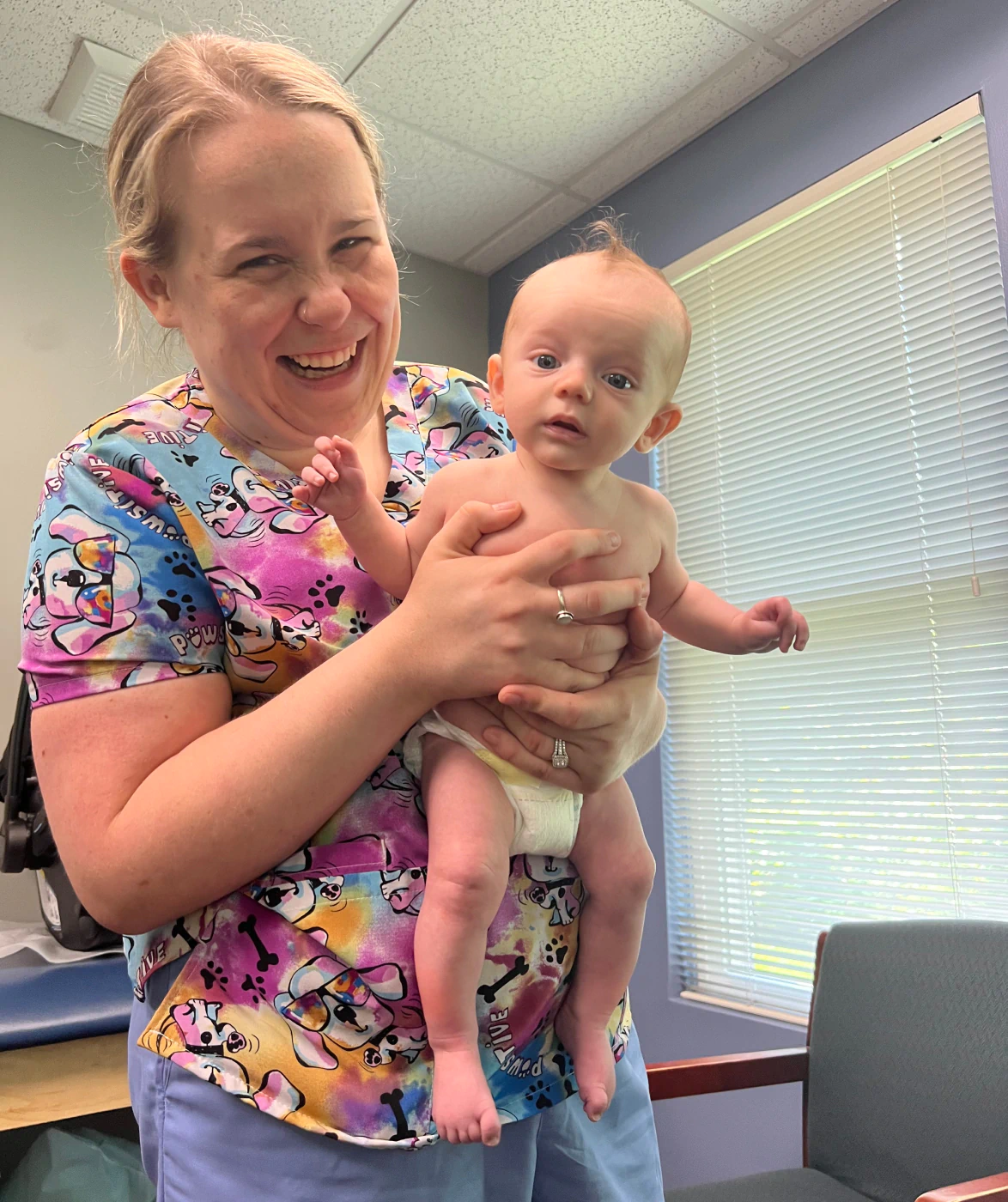 sarah stanton holding up a baby