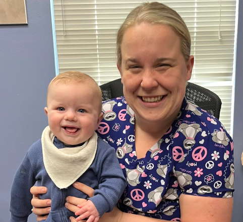 sarah stanton smiling with a baby on her arms